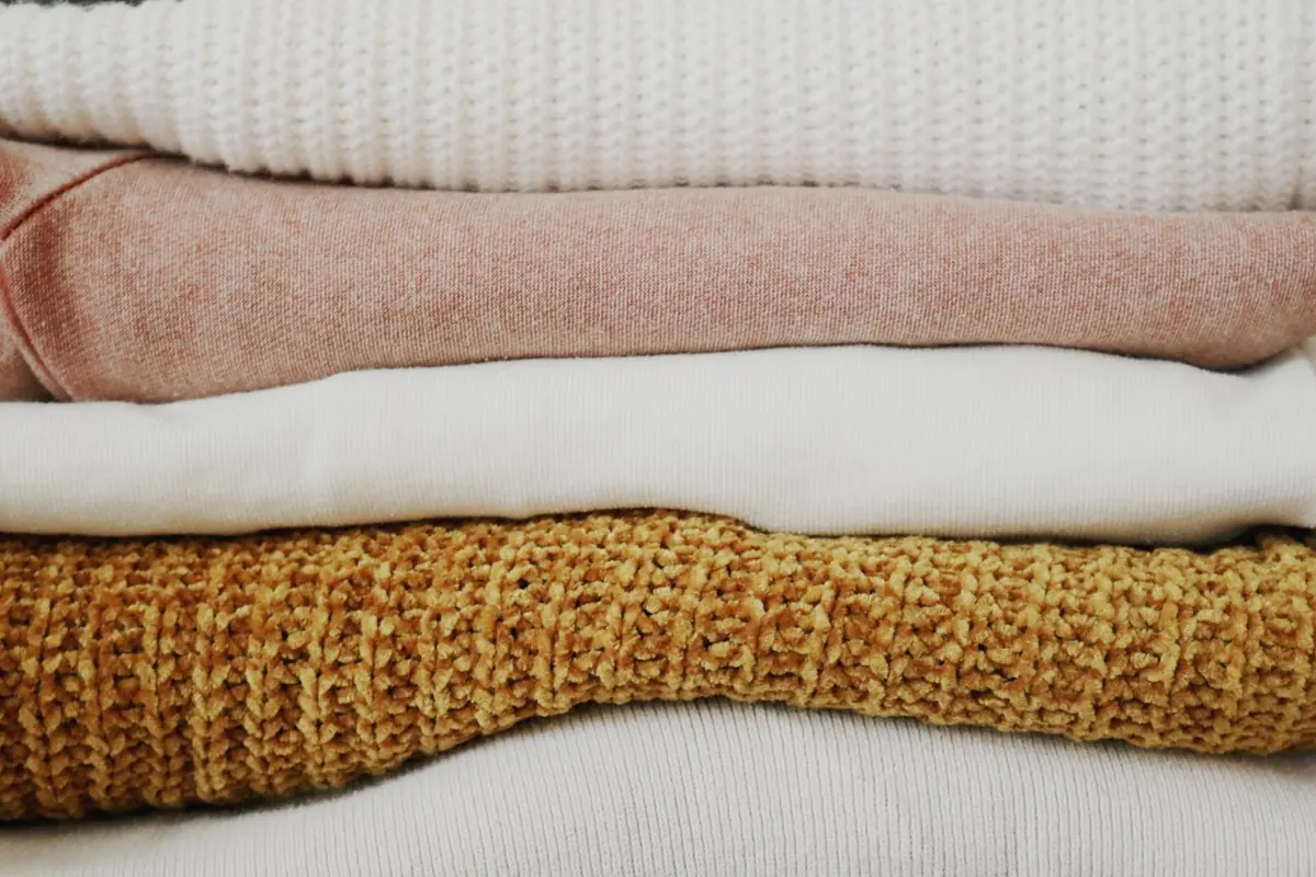 Pile de textiles pliés illustrant le soin et le rangement après traitement